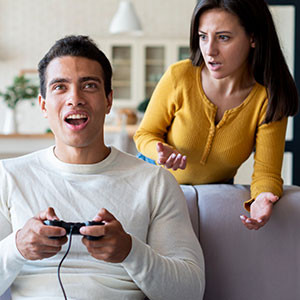 Paar diskutiert beim Videospielen im Wohnzimmer.